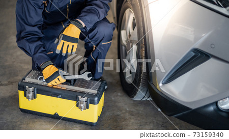 Asian auto mechanic checking the car wheel in garage Asian auto mechanic checking the car wheel in garage 73159340