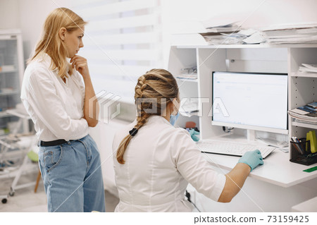 Doctor checks coronavirus test with patient 73159425