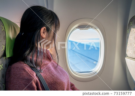 美麗的女人,從飛機裡邊看著窗外的紅色 美麗的女人,從飛機裡邊看著窗外的紅色 73159777