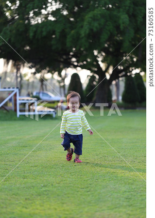 Asian boy is learning to walk in the garden. Asian boy is learning to walk in the garden. 73160585