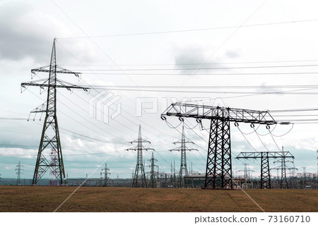 Electricity pylons conducting current from distribution power station, solar renewable energy and grid stability concept, copy space dramatic clouds Electricity pylons conducting current from distribution power station, solar renewable energy and grid stability concept, copy space dramatic clouds 73160710