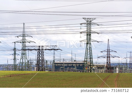 Electricity pylons conducting current from distribution power station, solar renewable energy and grid stability concept, copy space dramatic clouds Electricity pylons conducting current from distribution power station, solar renewable energy and grid stability concept, copy space dramatic clouds 73160712