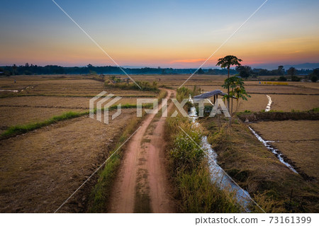 Aerial view of road pass through rice field after harvested in nan province, Northern Thailand Aerial view of road pass through rice field after harvested in nan province, Northern Thailand 73161399