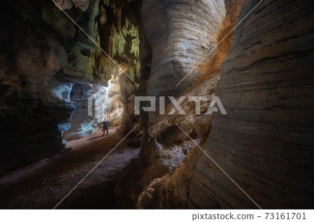 Man exploring the cave in Tam See Fah or Blue cave in Tak province, Thailand Man exploring the cave in Tam See Fah or Blue cave in Tak province, Thailand 73161701