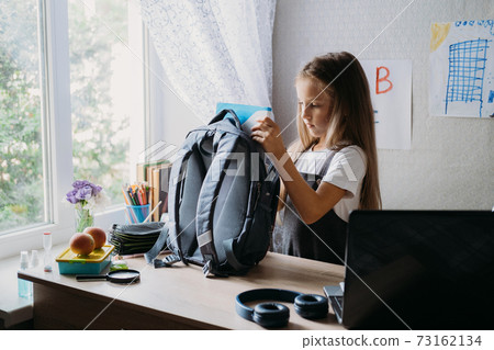 Back to school, schoolchildren hygiene, safety precautions after coronavirus. The schoolgirl is going to school and washing her hands with sanitizer Back to school, schoolchildren hygiene, safety precautions after coronavirus. The schoolgirl is going to school and washing her hands with sanitizer 73162134