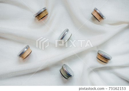 Nuts and seeds butter in glass jars on natural fabric background with copyspace. Homemade raw organic peanut, almond, coconut, hemp seeds, pumpkin seeds, macadamia nuts paste 73162153