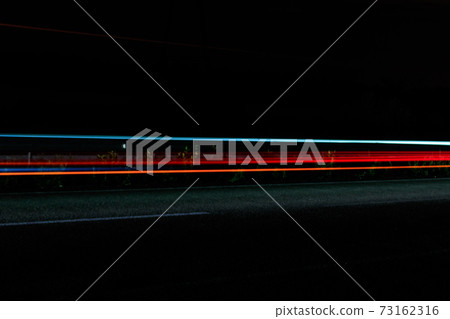 Traffic light trails on a highway at night 73162316