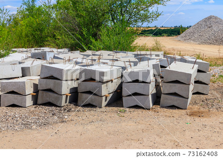 Stacks of the new concrete road curbs for road construction 73162408