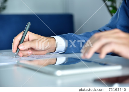 Financial auditor working in office and analyzing financial results. Financial auditor working in office and analyzing financial results. 73163540