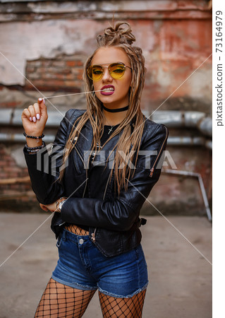 A woman in yellow glasses wearing pantyhose poses 73164979