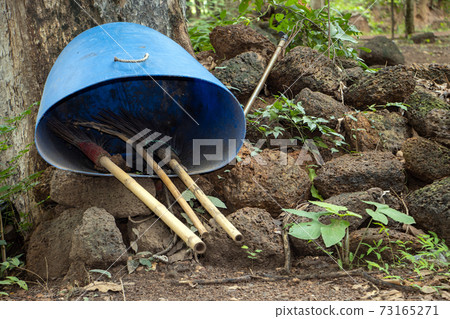 The brooms in a barrel ready to clean in the park. The brooms in a barrel ready to clean in the park. 73165271