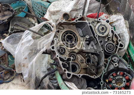 Disassembled motorcycle engine. Motorcycle powertrain parts under repair. Disassembled motorcycle engine. Motorcycle powertrain parts under repair. 73165273