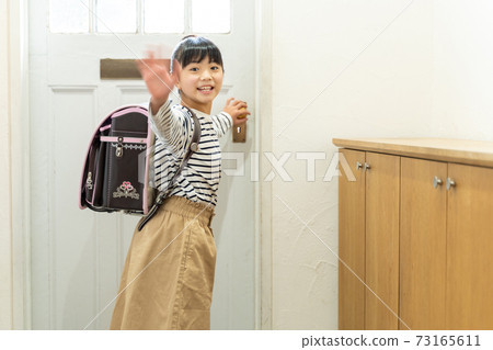 Elementary school girl standing at the entrance Elementary school girl standing at the entrance 73165611