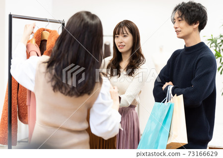 A couple shopping and a clerk A couple shopping and a clerk 73166629