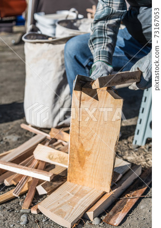 [Support the firewood with the stick on the left hand and chop the firewood with the hatchet on the right hand] 73167053