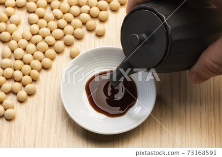 將醬油倒入一個小盤子裡 將醬油倒入一個小盤子裡 73168591