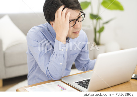 A man teleworking in his room A man teleworking in his room 73168902