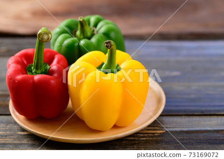Fresh yellow, red and green bell peppers on wooden background, Organic vegetables Fresh yellow, red and green bell peppers on wooden background, Organic vegetables 73169072