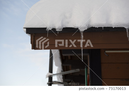 Icicles falling from the snow on the roof Icicles falling from the snow on the roof 73170013