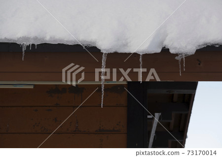 Icicles falling from the snow on the roof Icicles falling from the snow on the roof 73170014