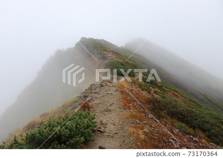 Mountain trail to Mt. Shirouma with poor visibility in the fog Mountain trail to Mt. Shirouma with poor visibility in the fog 73170364