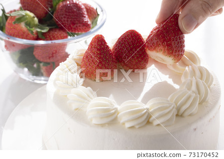 Make a cake and put strawberries on it 73170452