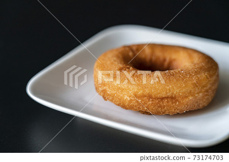 Donuts on a white plate [black background] 73174703