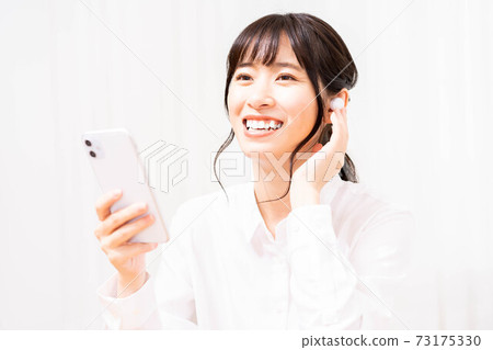 聽到在智能手機的音樂的一個少婦 聽到在智能手機的音樂的一個少婦 73175330