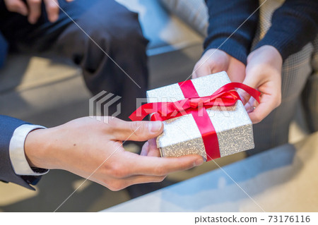 Woman handing valentine chocolate 73176116