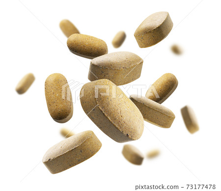 Yellow tablets levitate on a white background Yellow tablets levitate on a white background 73177478