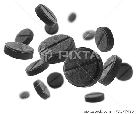 Black activated carbon tablets levitate on a white background 73177480