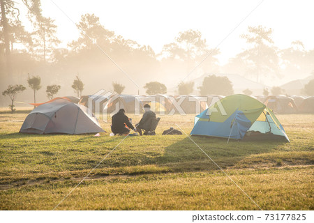two men sitting near camping tent two men sitting near camping tent 73177825