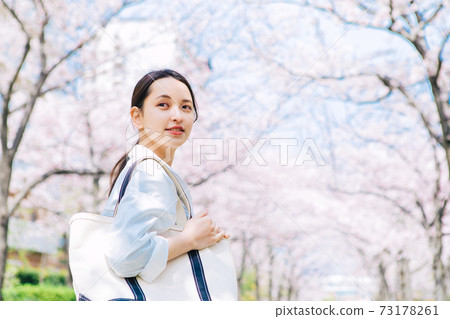 一位年輕的女士，沿著櫻花走 73178261