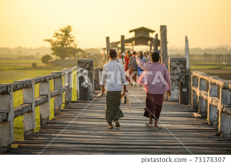 Burmese woman walk on U Bein Bridge, Myanmar Burmese woman walk on U Bein Bridge, Myanmar 73178307