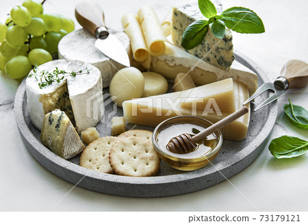 Various types of cheese, grapes and honey Various types of cheese, grapes and honey 73179121