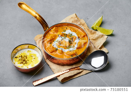 Murgh Makhani or Butter Chicken in copper bowl on gray concrete table top. Indian Cuisine dish Murgh Makhani or Butter Chicken in copper bowl on gray concrete table top. Indian Cuisine dish 73180551