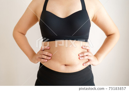 Women body fat belly. Obese woman hand holding excessive belly fat. diet lifestyle concept to reduce belly and shape up healthy stomach muscle. 73183857