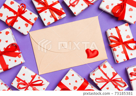 Top view of colorful valentine background made of craft envelope, gift boxes and red textile hearts. Valentine's Day concept 73185381