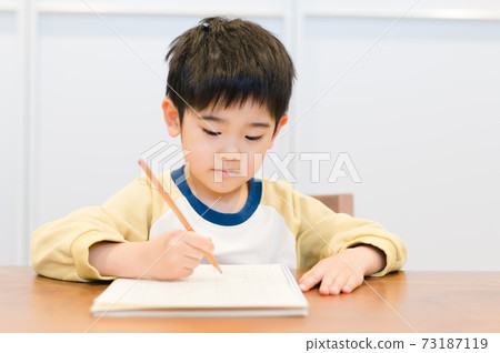 Boy studying at the living room table 73187119
