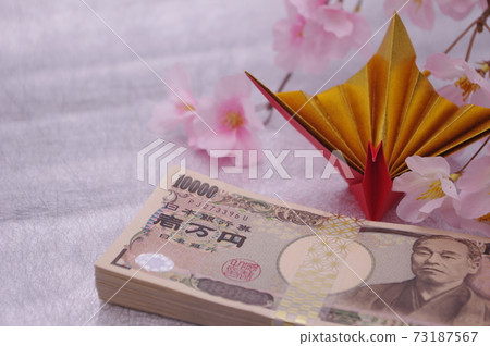An image of a spring celebration or anniversary with origami celebration cranes and artificial flower cherry blossoms attached to the money wrapped in a traditional Japanese pattern strap An image of a spring celebration or anniversary with origami celebration cranes and artificial flower cherry blossoms attached to the money wrapped in a traditional Japanese pattern strap 73187567