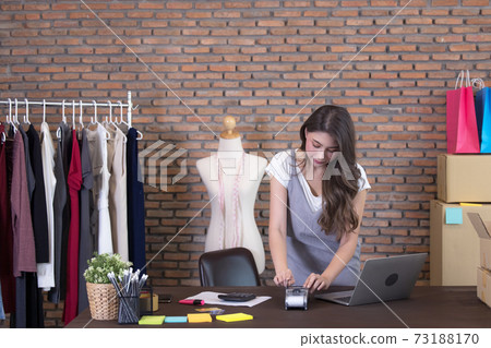 Young woman tailor with laptop is answering emails, Business woman entrepreneurial success . Sales Online Parcel delivery Young woman tailor with laptop is answering emails, Business woman entrepreneurial success . Sales Online Parcel delivery 73188170