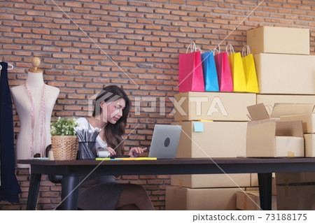 Young woman tailor with laptop is answering emails, Business woman entrepreneurial success . Sales Online Parcel delivery Young woman tailor with laptop is answering emails, Business woman entrepreneurial success . Sales Online Parcel delivery 73188175