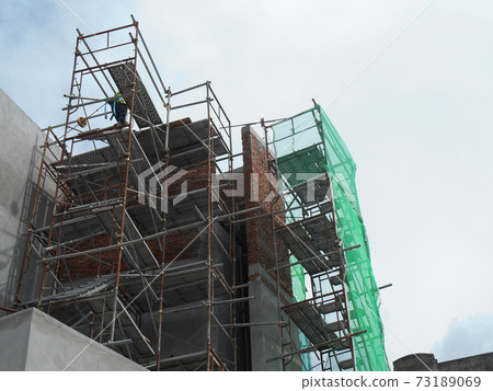 MALACCA, MALAYSIA -MAC 29, 2017: Construction workers used metal scaffolding when working at height at the construction site. They are required to wear the necessary safety equipment to do so.  73189069