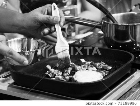Chef cooking in a kitchen, chef at work, Black and White. Chef cooking in a kitchen, chef at work, Black and White. 73189986