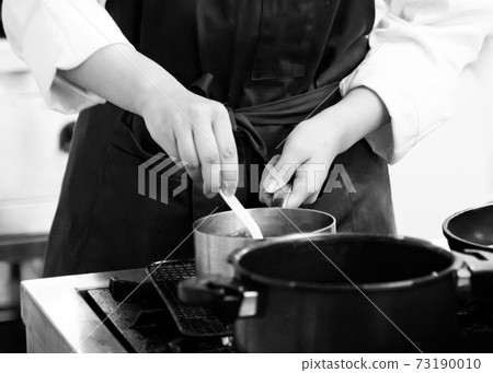 Chef cooking in a kitchen, chef at work, Black and White. 73190010