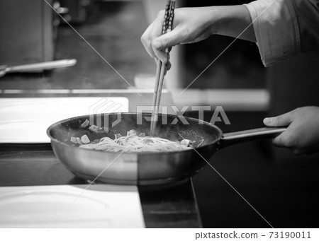 Chef cooking in a kitchen, chef at work, Black and White. Chef cooking in a kitchen, chef at work, Black and White. 73190011