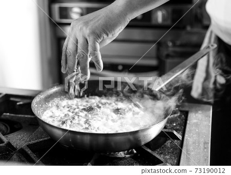 Chef cooking in a kitchen, chef at work, Black and White. Chef cooking in a kitchen, chef at work, Black and White. 73190012