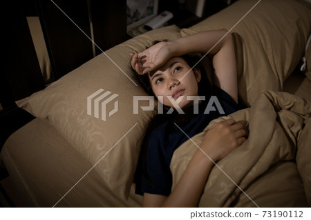 Young asian woman cannot sleep insomnia late at night. Can't sleep. Sleep apnea or stress. Sleep disorder concept. Young asian woman cannot sleep insomnia late at night. Can't sleep. Sleep apnea or stress. Sleep disorder concept. 73190112