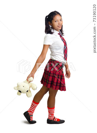 schoolgirl holding a teddy bear 73190120