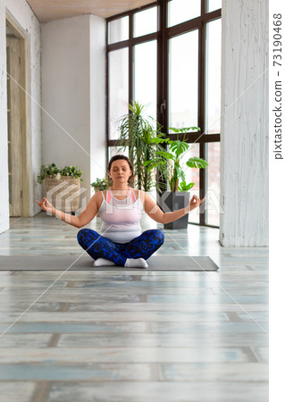 Vertical photo of a woman meditating at home. Health care concept. Vertical photo of a woman meditating at home. Health care concept. 73190468
